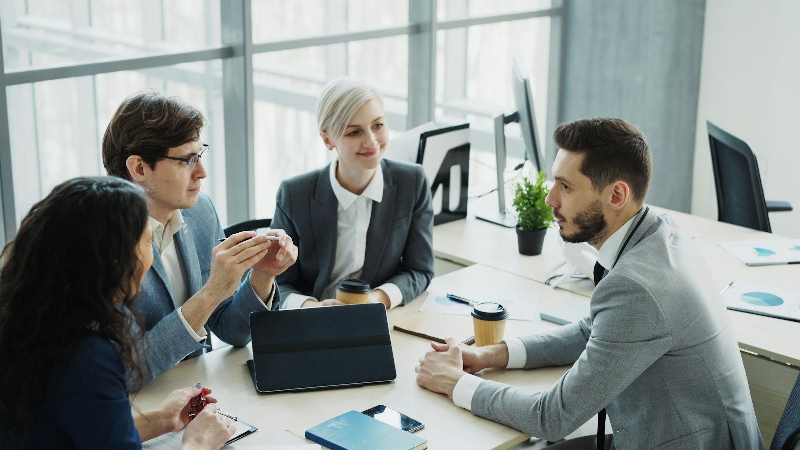 Colleagues meeting around a table in a bright office